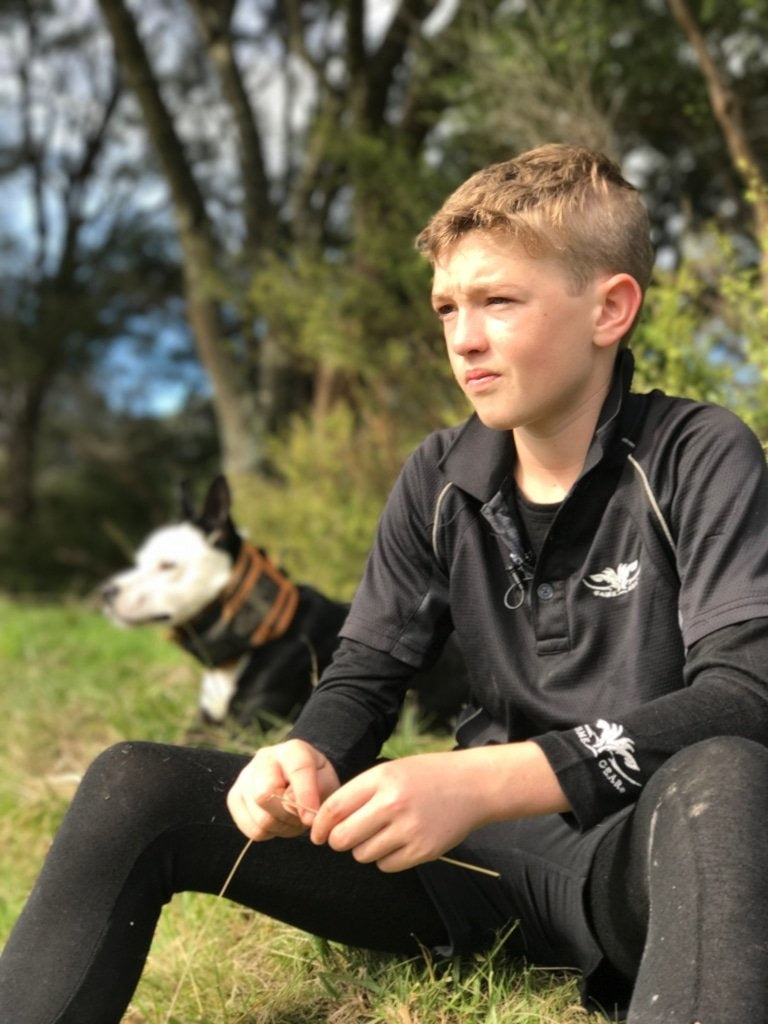 Boy wearing lightweight black quick dry polo shirt with his hunting dog